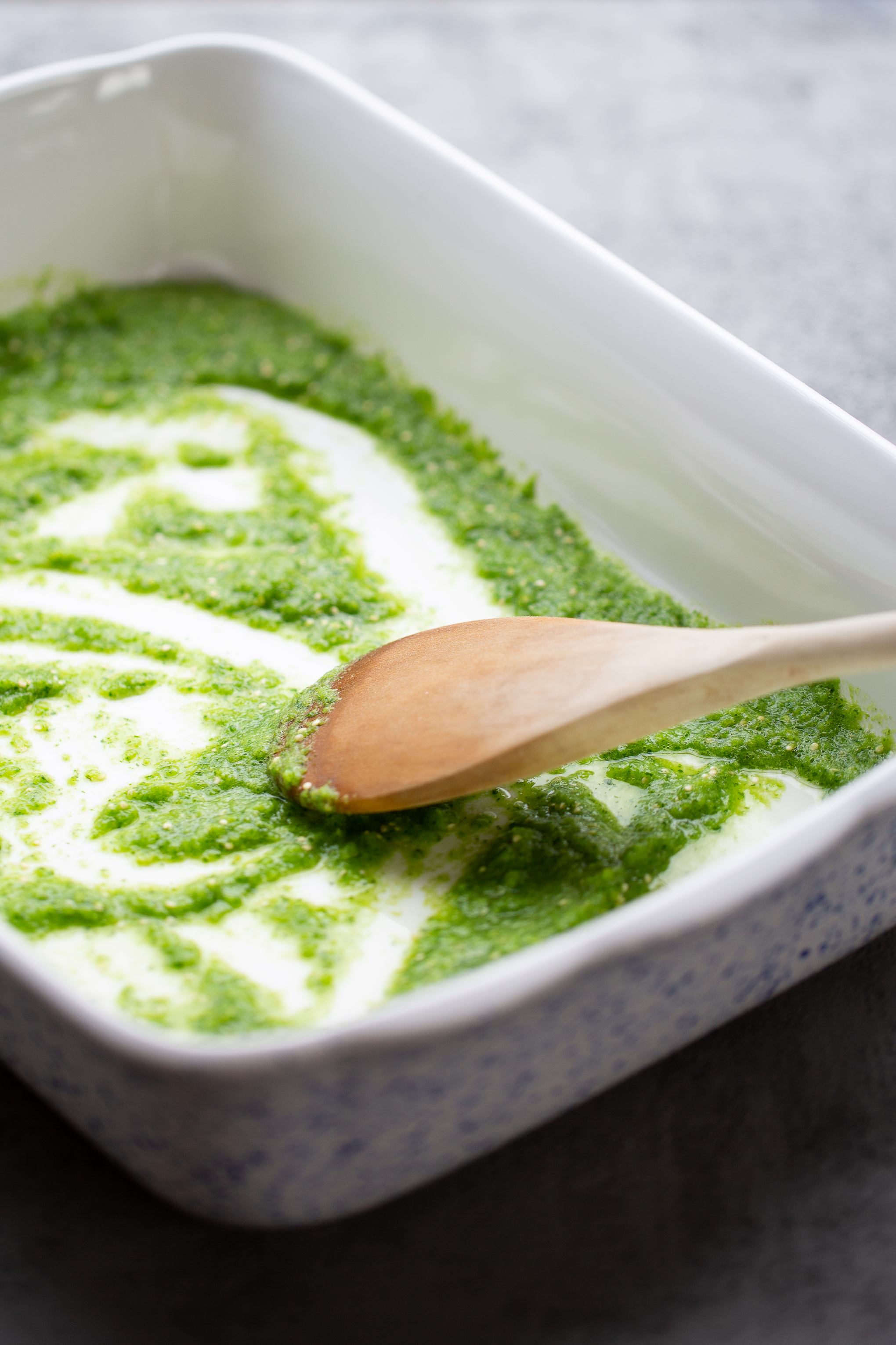 saucing a baking dish with salsa verde