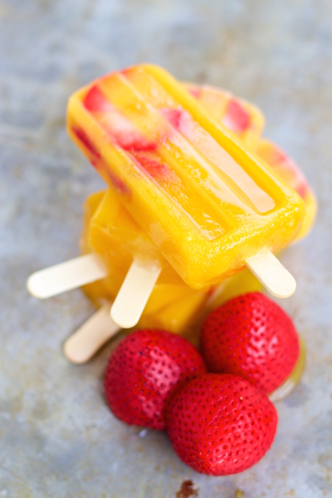 mango and strawberry paletas stacked one on top of the other