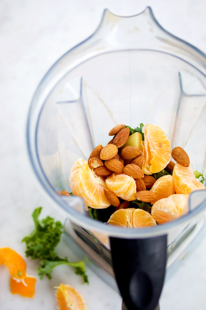 kale mandarin and almonds in a blender jar