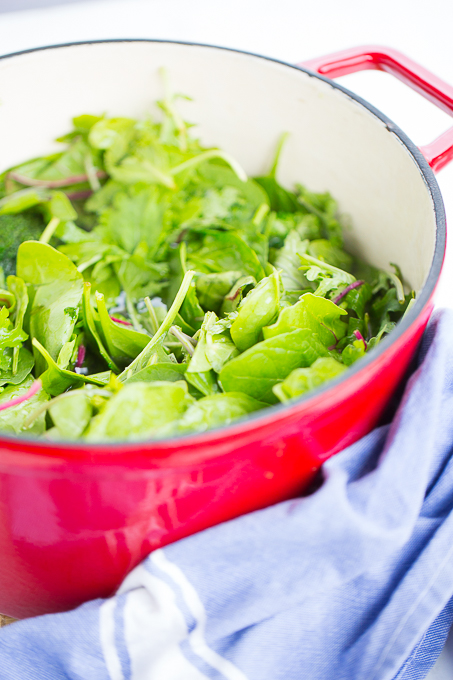 red dutch oven with greens