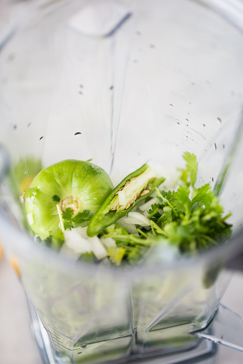 tomatillos, serrano cilantro and onion in the blender container