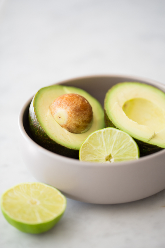 Avocados and limes in abowl.