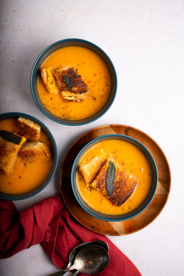 Vegan Butternut squash soup with grilled cheese croutons in a blue bowl
