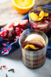 Mulled wine with apple slices and pomegranate seeds.