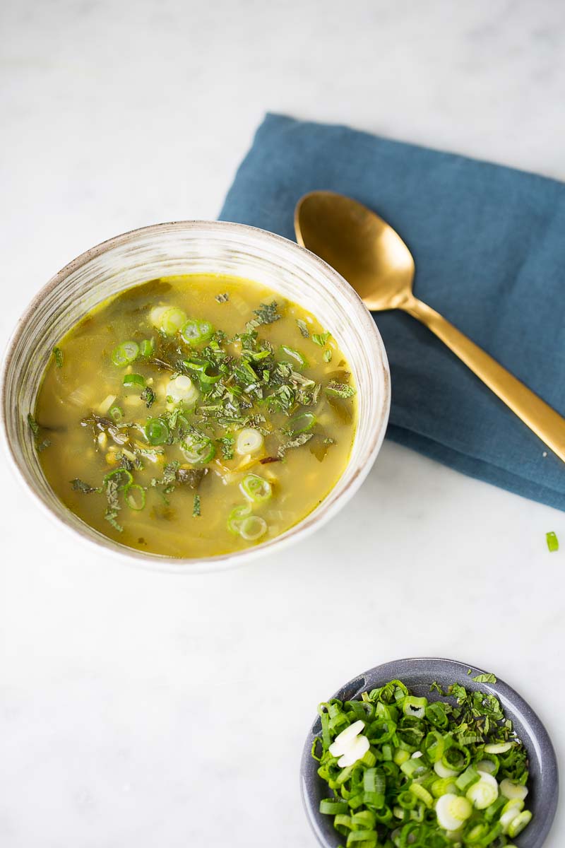 a bowl of  vegan split pea soup with fresh herbs and rice