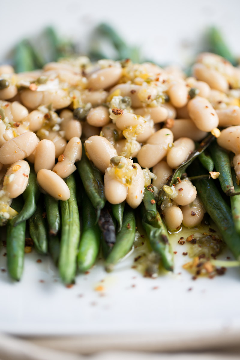 navy beans and preserved lemond with capers dressing over roasted green beans