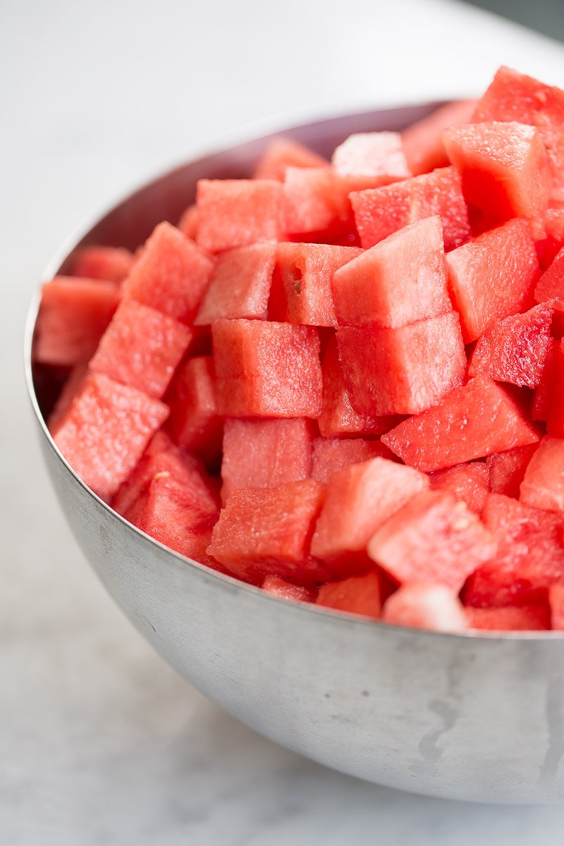 Cubes watermelon in a stainless steel bowl.