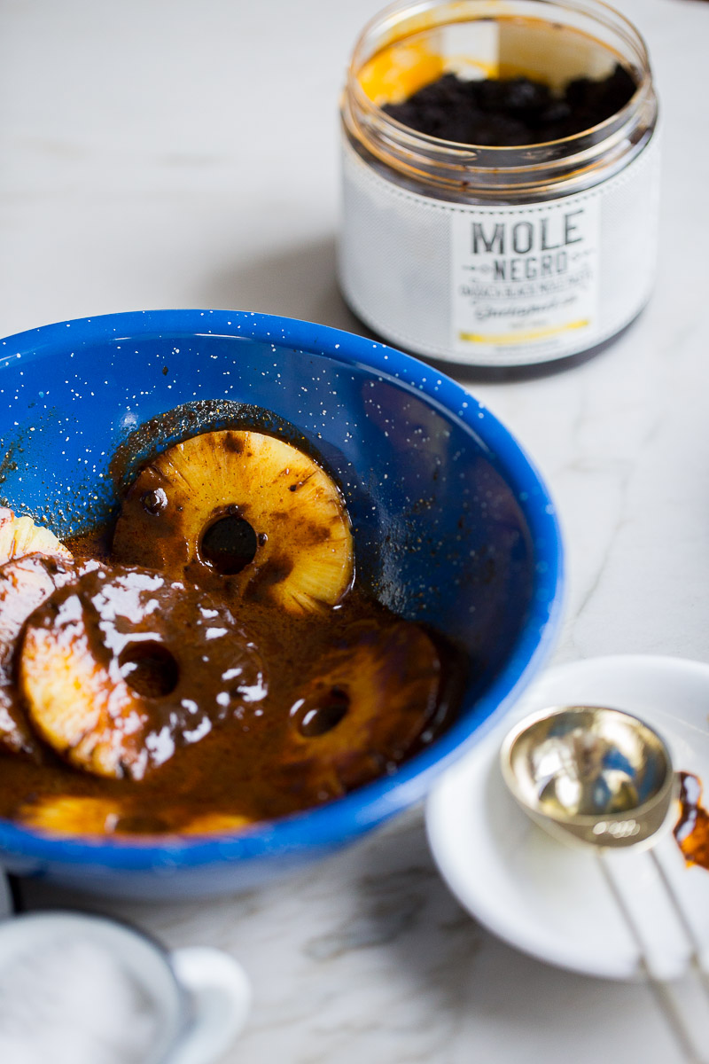 pineapple slices marinating in mole sauce