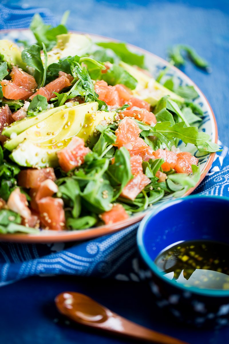 grapefruit arugula salad with avocado abd shallot dressind drizzles on top.