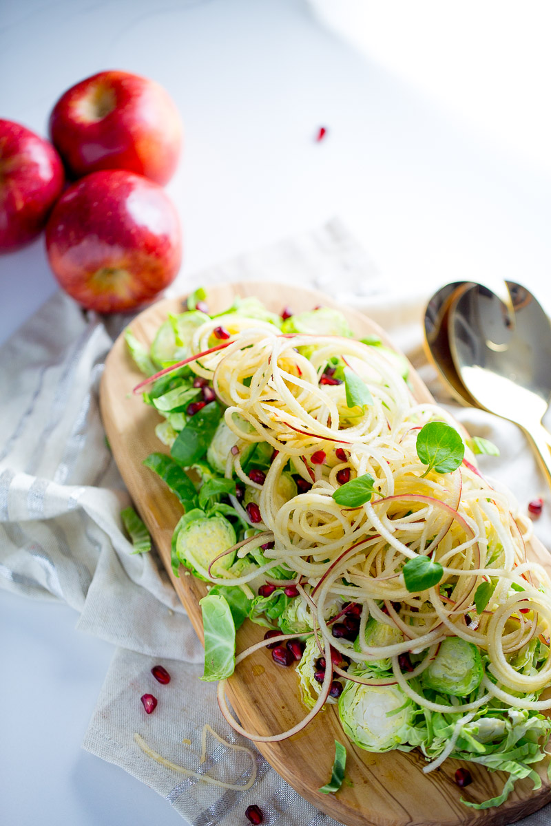 Apple salad with brussels sprouts, pomegranate seeds, and maple- balsamic vinegar dressing