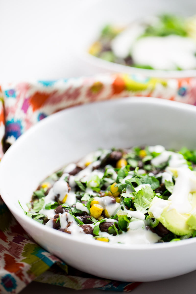 kale and black bean soup topped with avocado and mexican crema