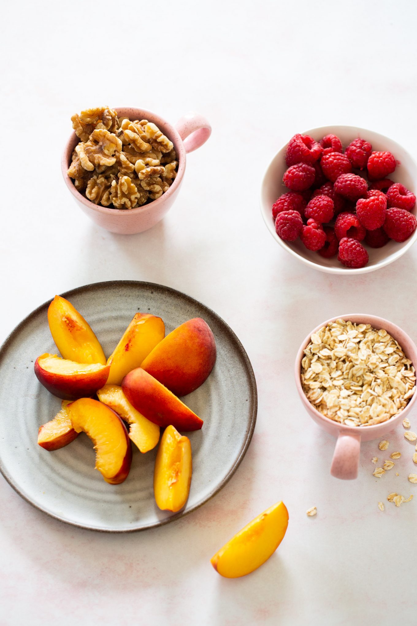 Peaches, raspberries, nuts and oats in dishes
