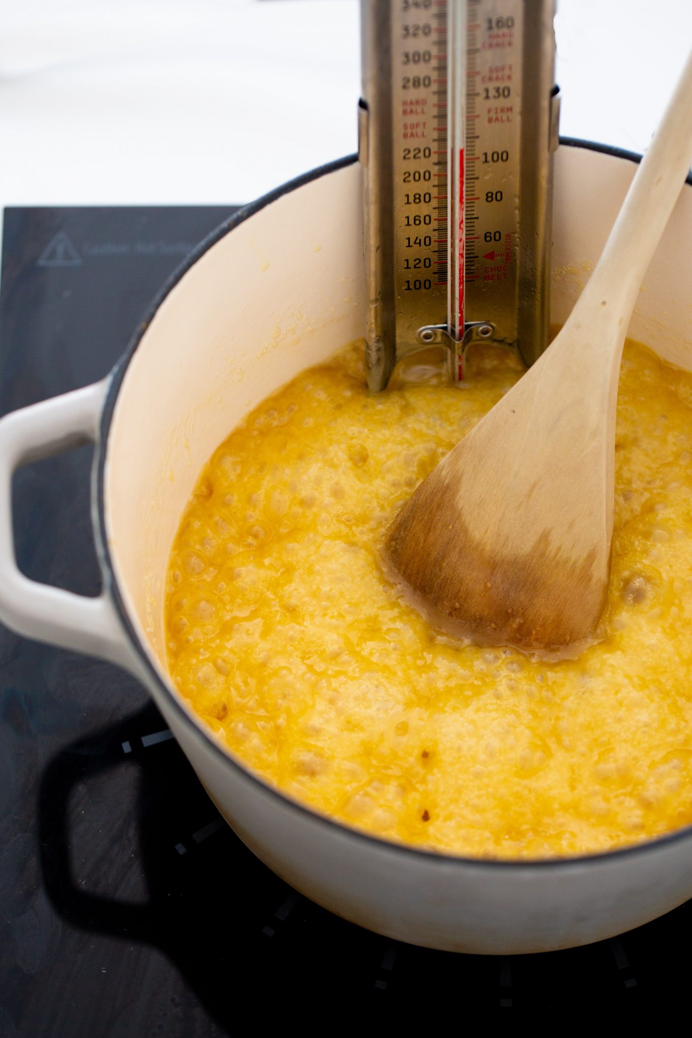 Butter and sugar in a iron cast pot with a termometer