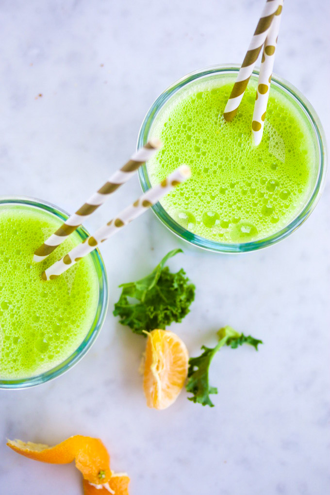 Jugo de kale, naranja y almendra dos vasos con licuado verde de mandarina y kale