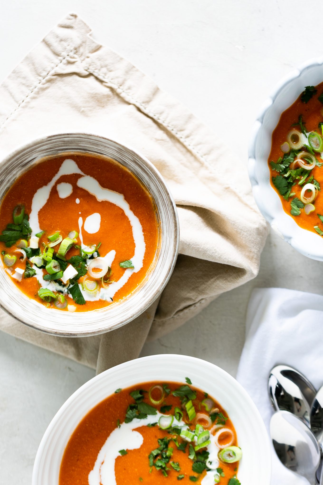 Three bowls of spicy creamy tomato soup