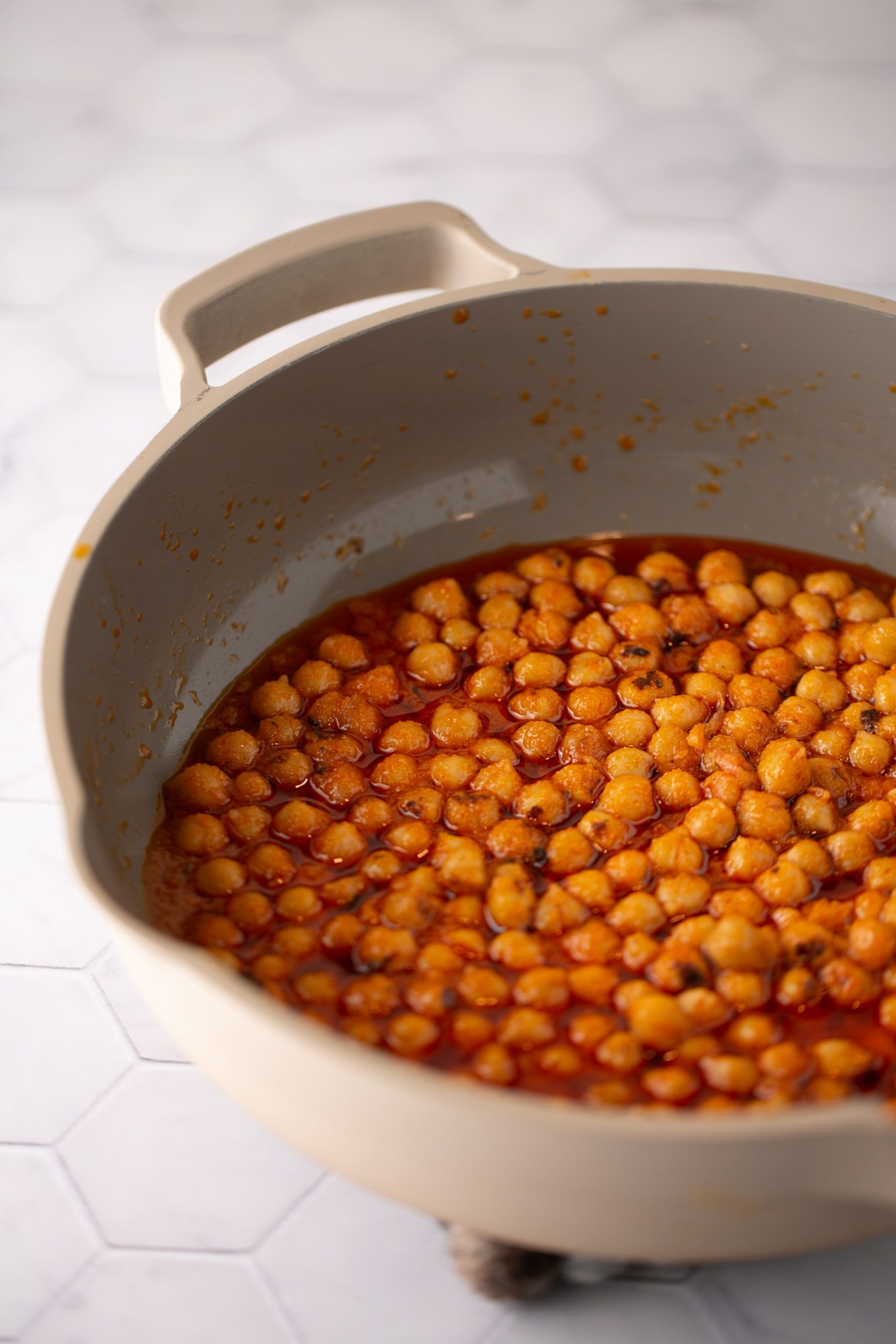 chickpeas drenched in homemade buffalo sauce in a frying pan