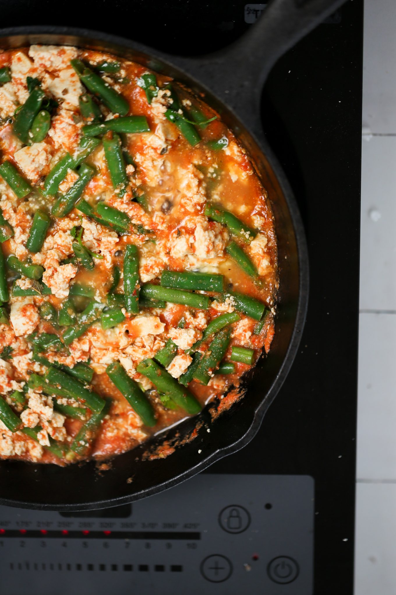 cooked green beans, tofu and red sauce