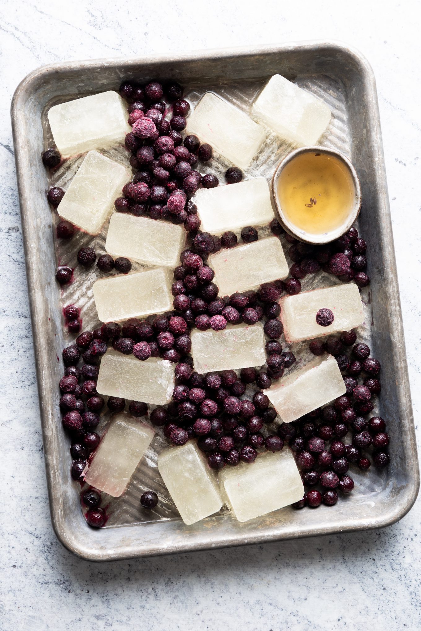  Baking sheet with ice cubes and frozen blueberries.