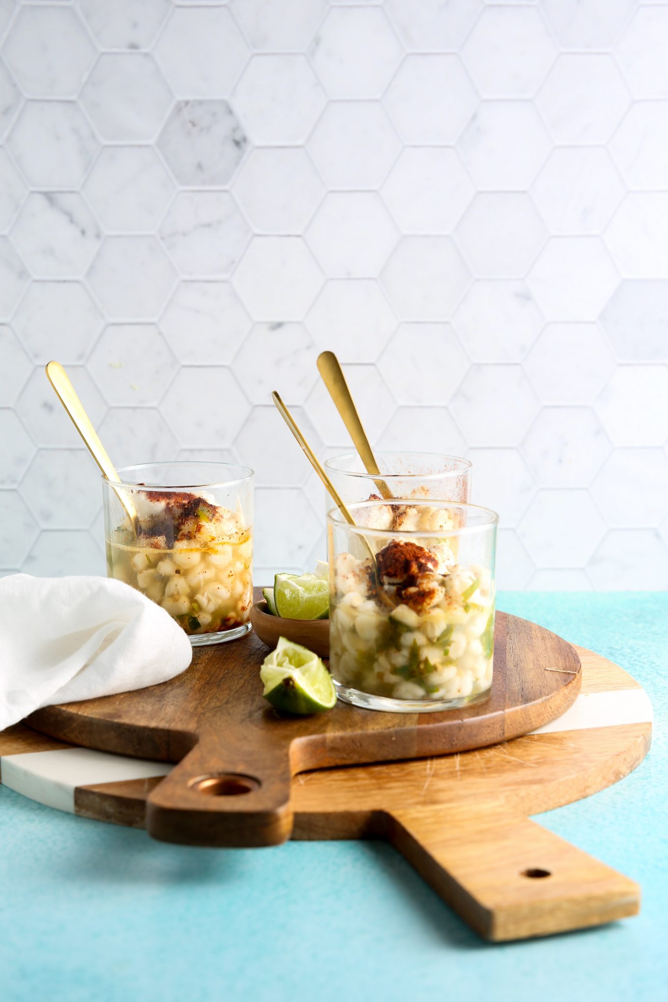 Three esquites glasses on two wooden cutting boards