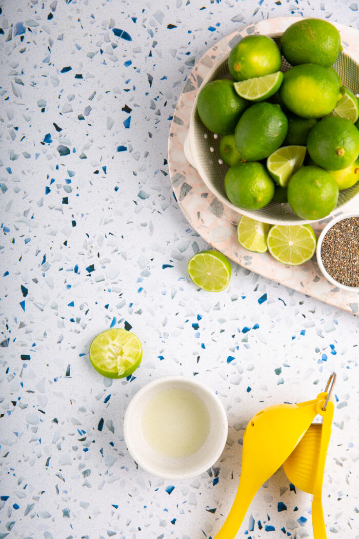 limes, chia seeds and susgar next to a yellow citrus presser