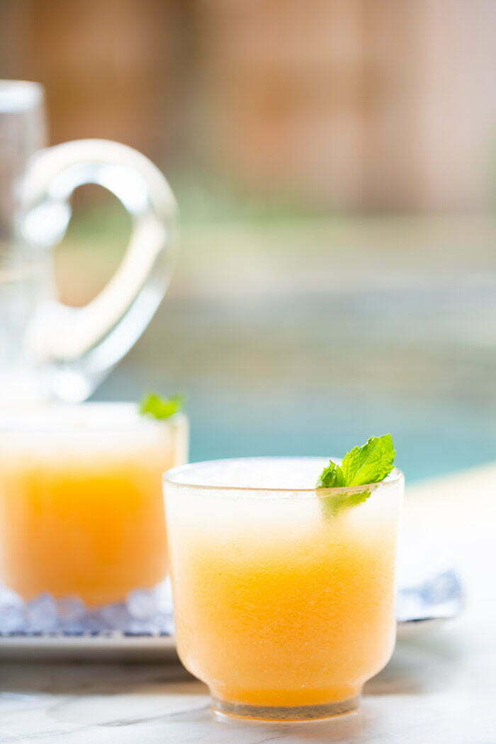 agua fresca de melon in a frosted cup with a mint leave as garnish
