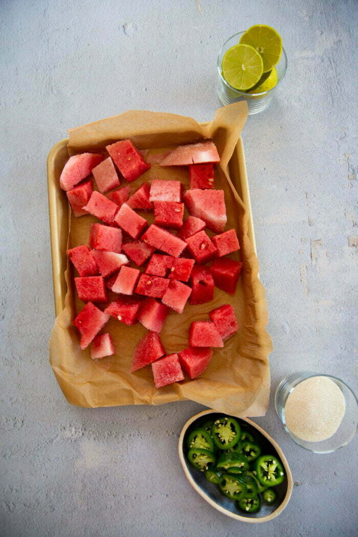 frozen watermelon chuncks over a baking sheet with parchement paper.