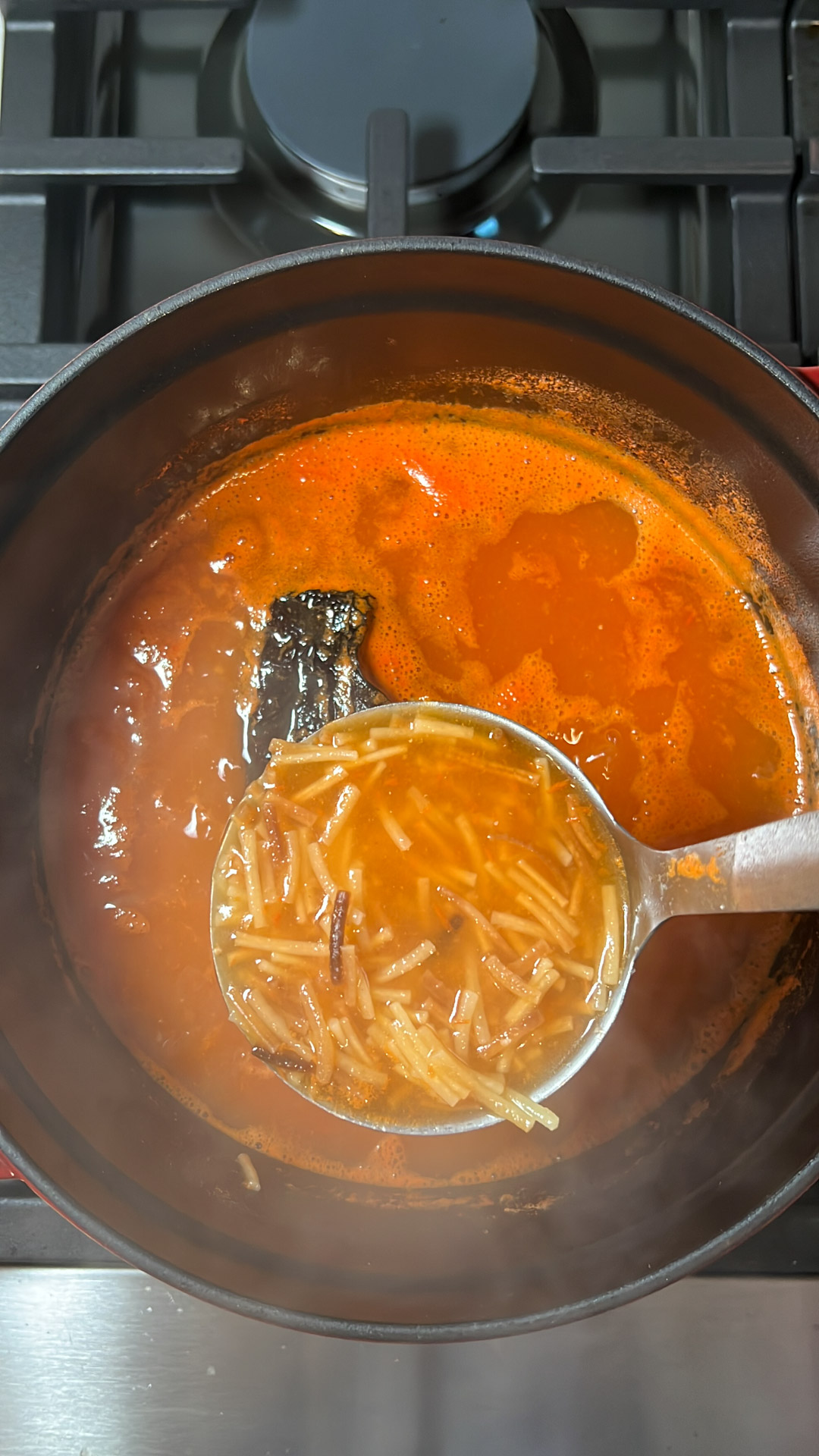 a ladle with mexican noodle soup.