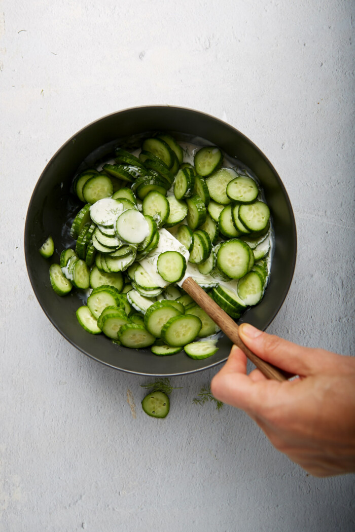 thinly sliced persian cucumbers in a matte black bowl.