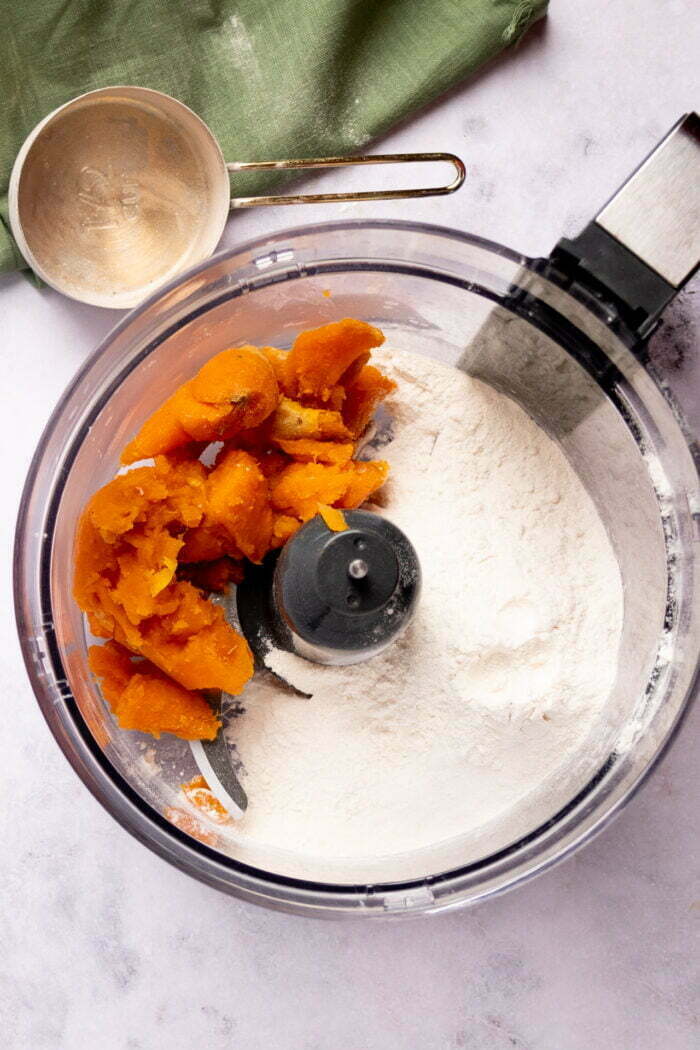 Mashed sweet potatoand self-rising flour in a food processor container